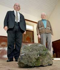 The Mayor of Ballymoney Councillor John Finlay standing with a lodge member beside the huge rock which broke the Orange Lodge window . Another 'Hate' attack by republicans against the Protestant community